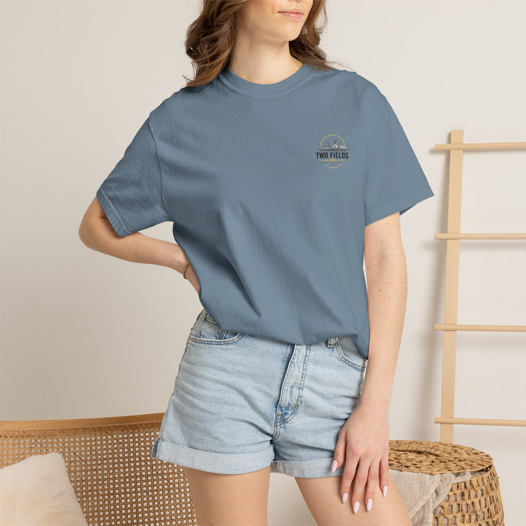 Dusty blue graphic T-shirt on model, chest shows small Two Fields logo