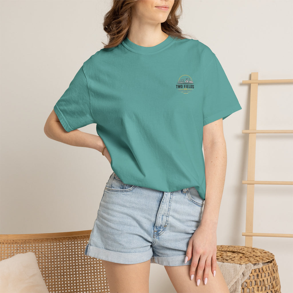 Teal t-shirt worn by model with small “Two Fields Co.” chest logo