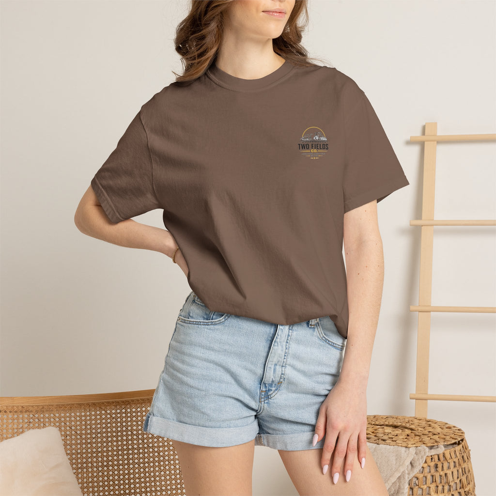 Brown crew-neck T-shirt on model with small Two Fields Co. chest graphic