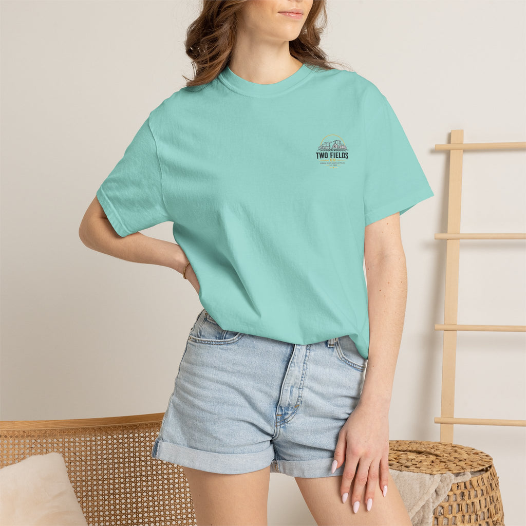 Light teal T-shirt with small Two Fields Co. logo on chest worn by model