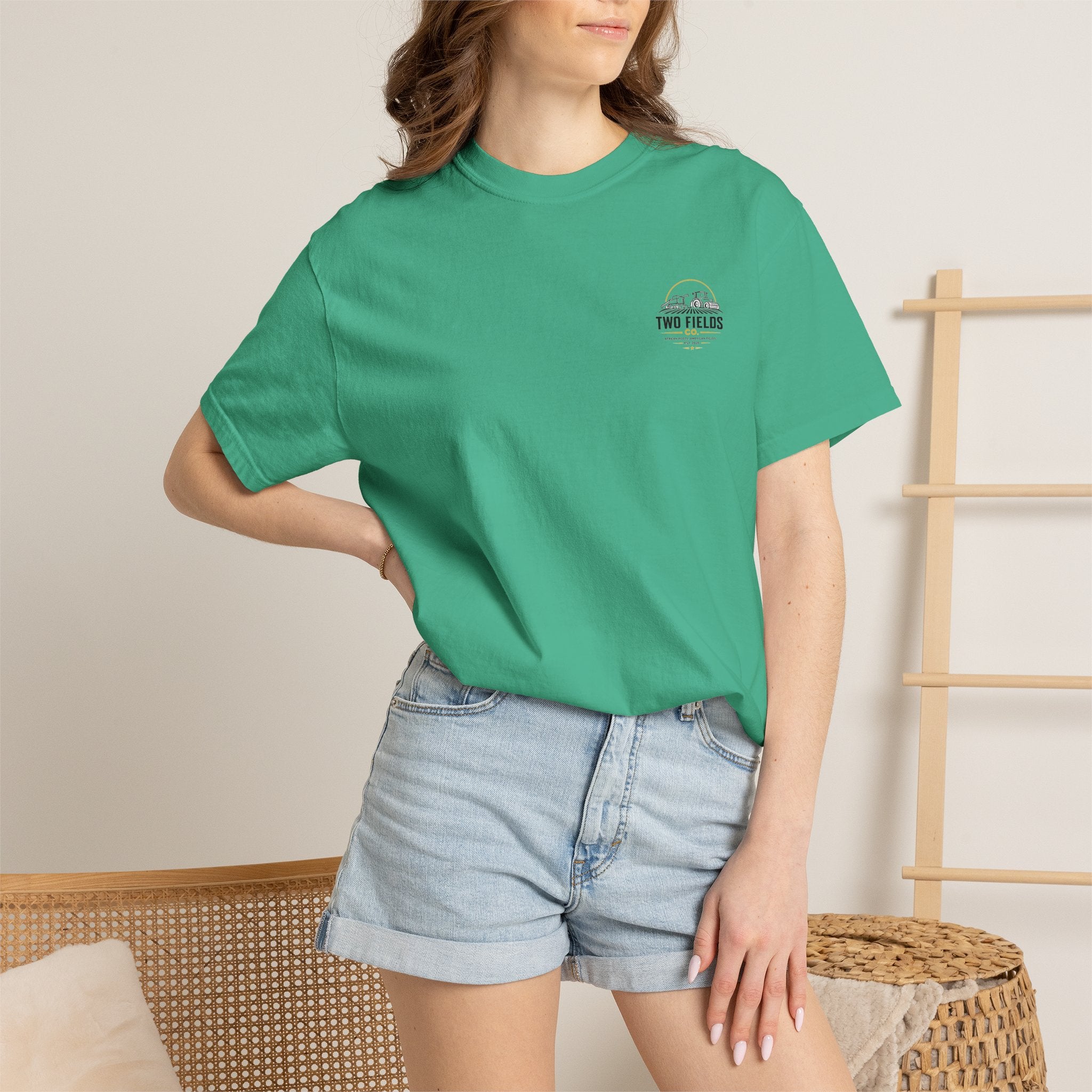 Green short-sleeve T-shirt worn with jeans, featuring a small chest logo