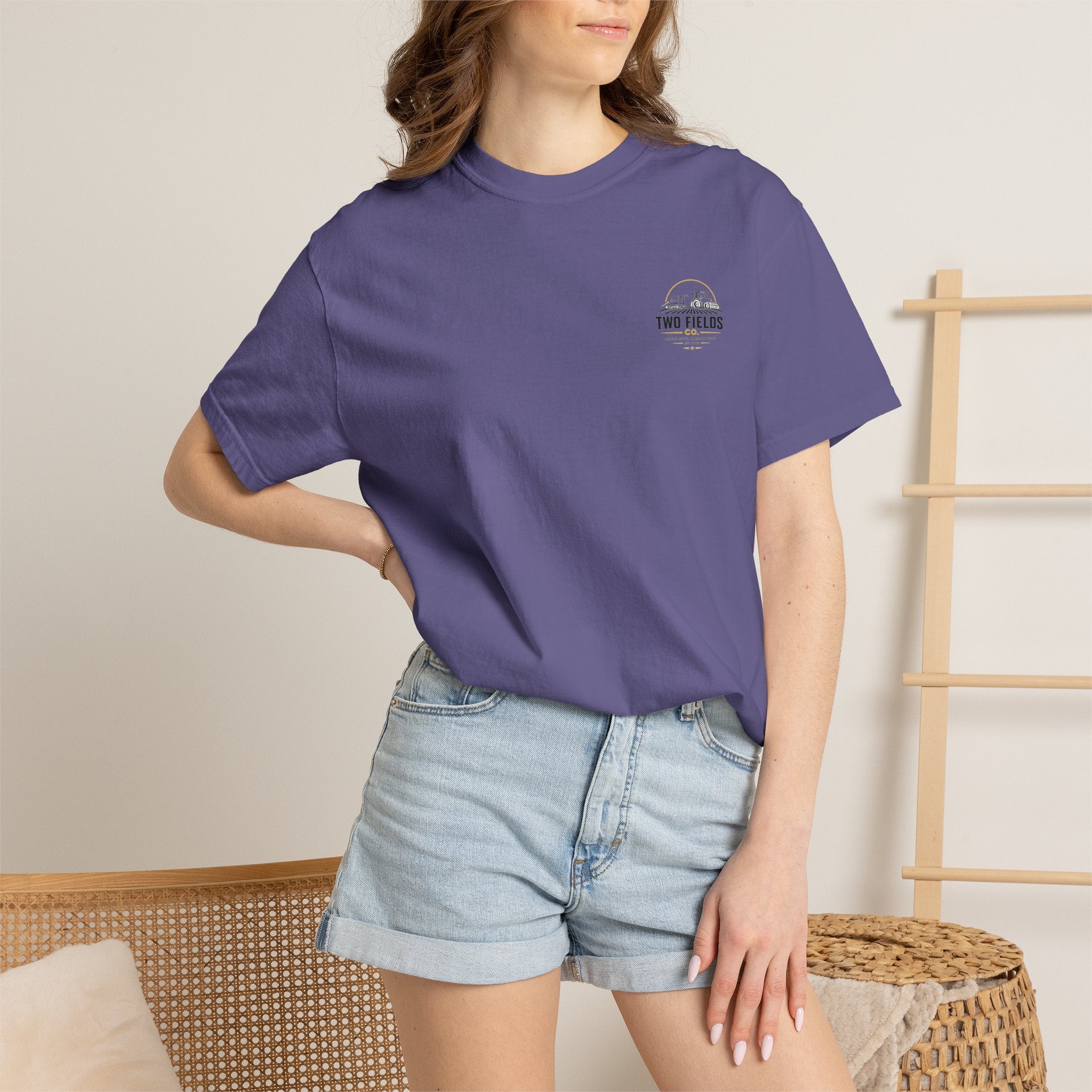 Purple short-sleeve T-shirt with small chest logo, worn by model