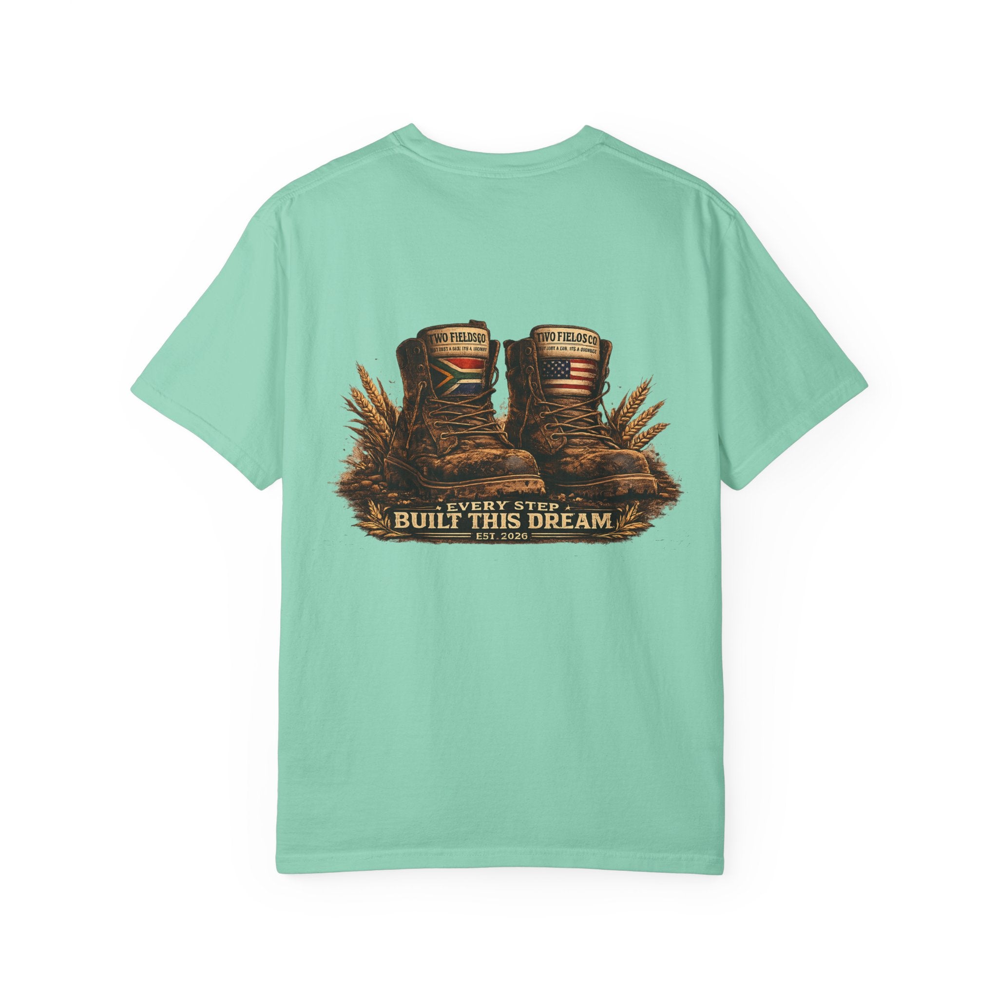 Mint green graphic T-shirt with brown work boots and gold “Every Step Built This Dream” text