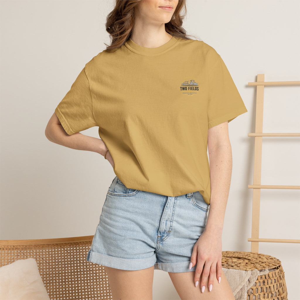 Model wearing a tan T-shirt with small chest logo
