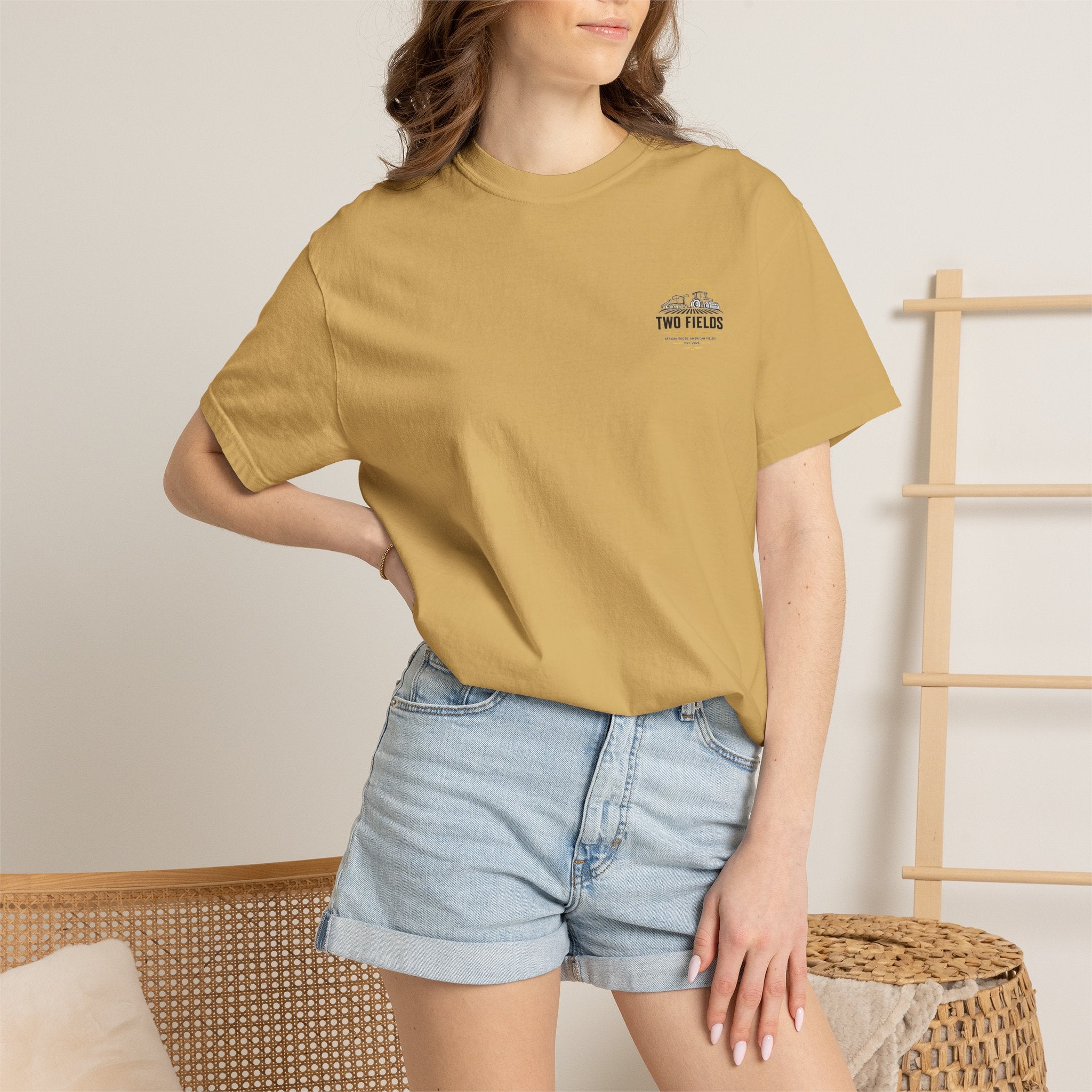 Model wearing a tan T-shirt with small chest logo