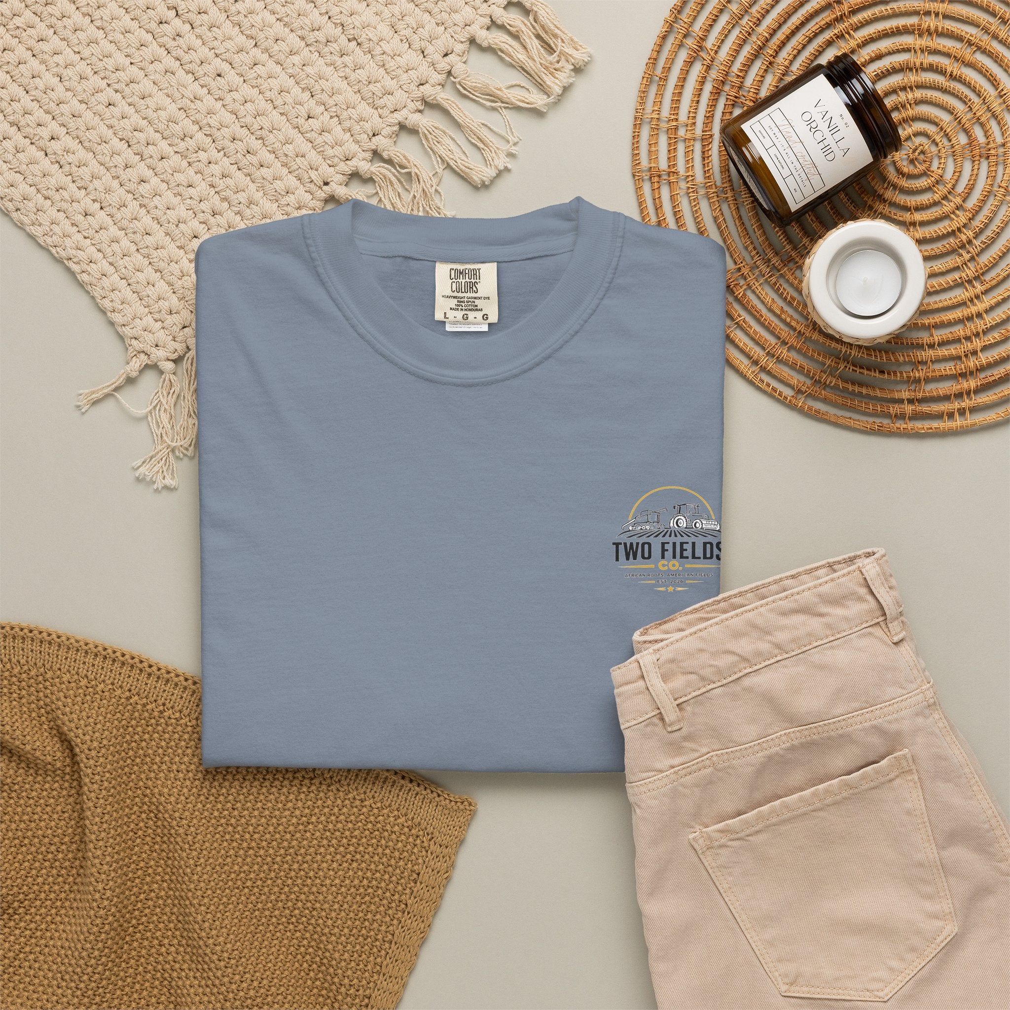 Light blue crewneck T-shirt laid flat with small Two Fields Co. tractor graphic