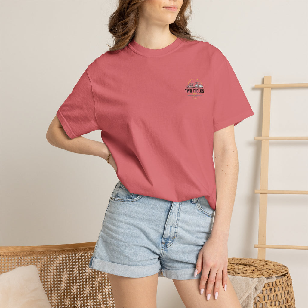 Model wearing light pink short-sleeve T-shirt with Two Fields Co. logo on the chest