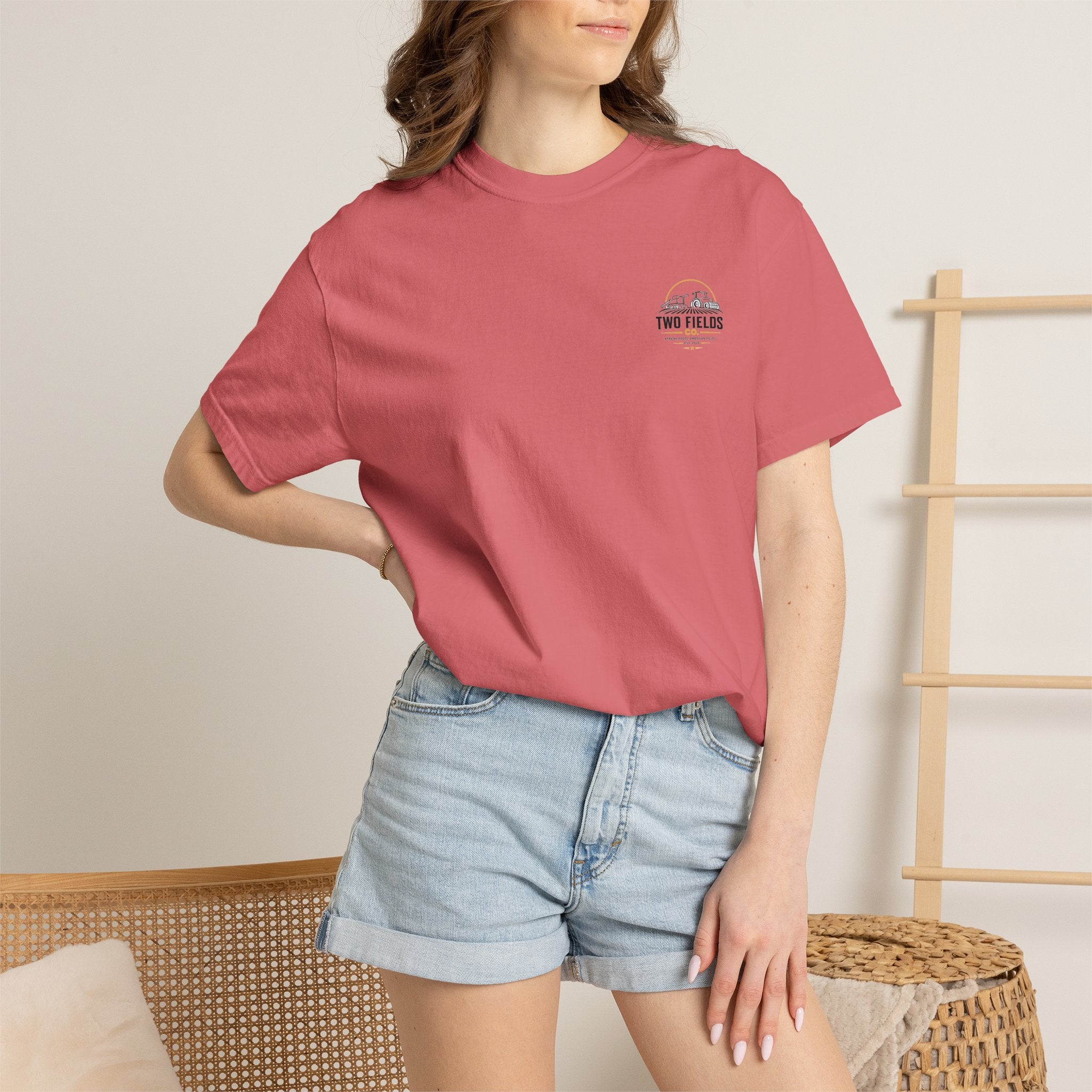 Model wearing light pink short-sleeve T-shirt with Two Fields Co. logo on the chest