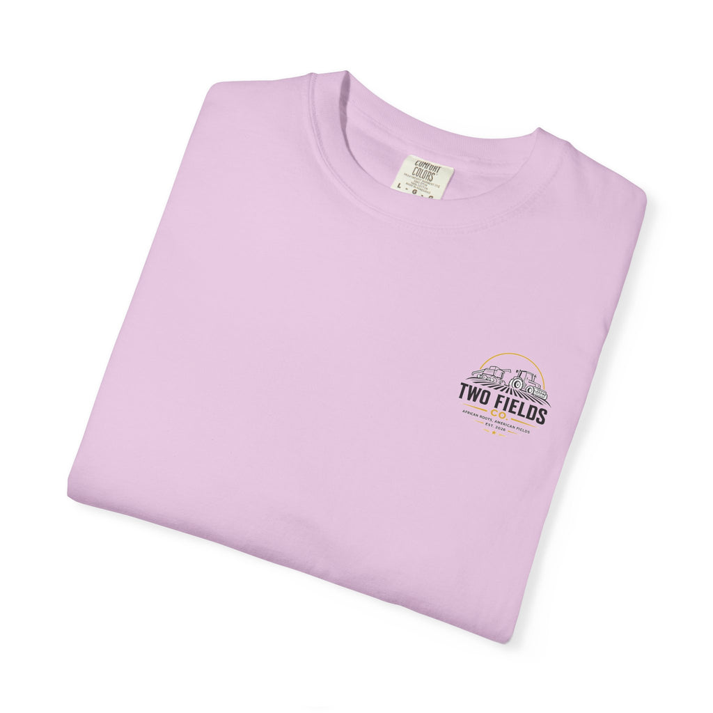 Lilac folded T-shirt with small Two Fields Co. mountain logo on chest