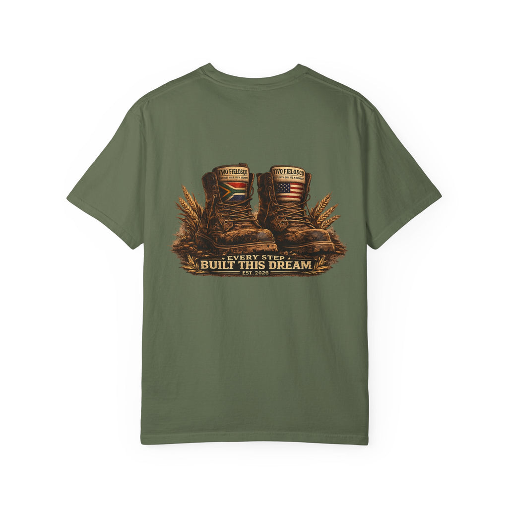 Olive green graphic T-shirt with brown work boots and “Every Step Built This Dream” text