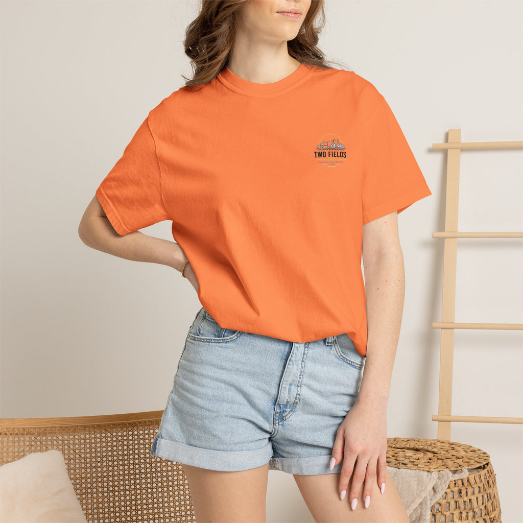 Rust-orange short-sleeve farm tractor graphic t-shirt worn with denim shorts